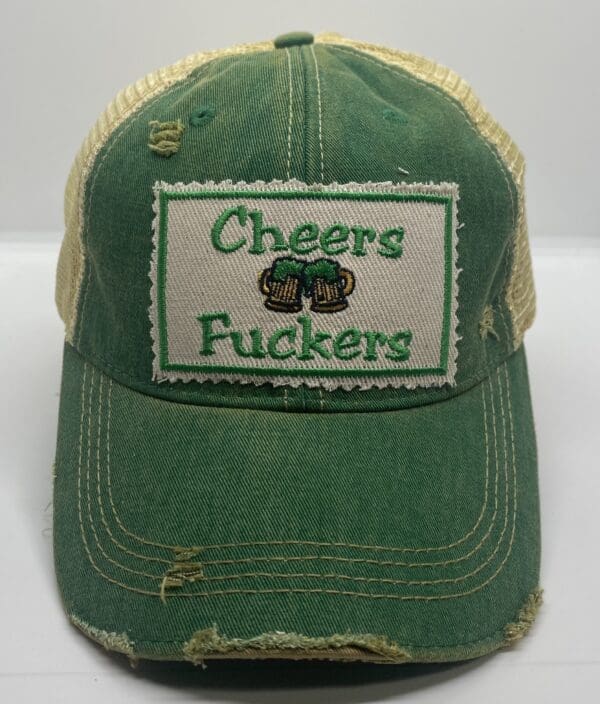 A green hat with the words cheers fuckers on it.