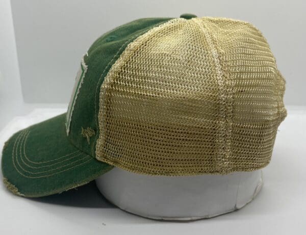 A green and tan hat with a patch on it.