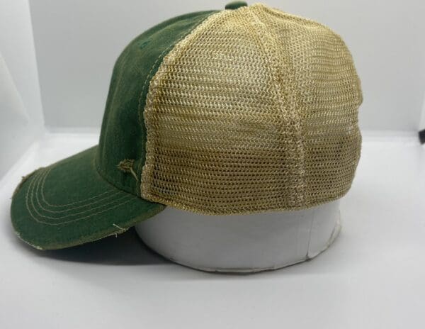 A green and tan hat sitting on top of a white table.